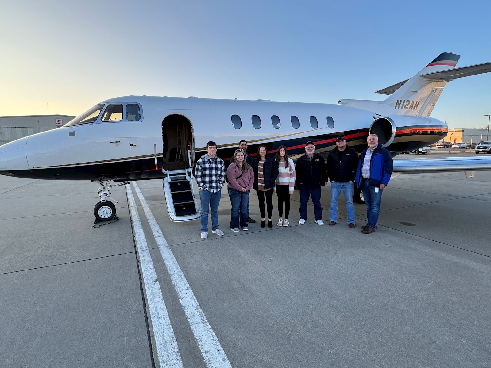 Photo of Les Bohlken and his family qith TMC's private jet