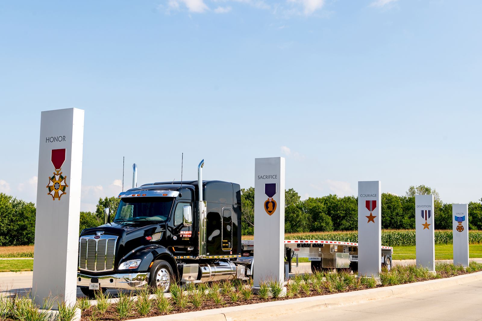 TMC truck and emblems representing each branch of the armed forces