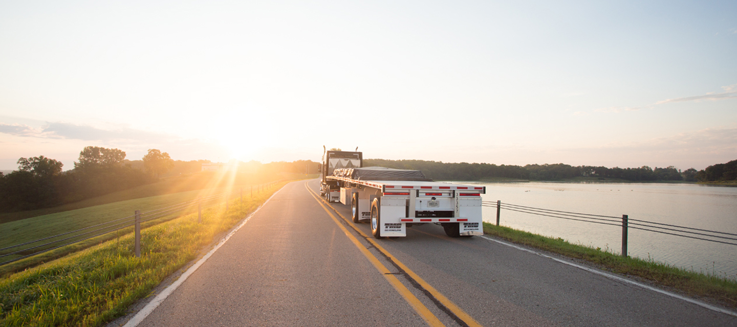 flatbed truck riding into sunset